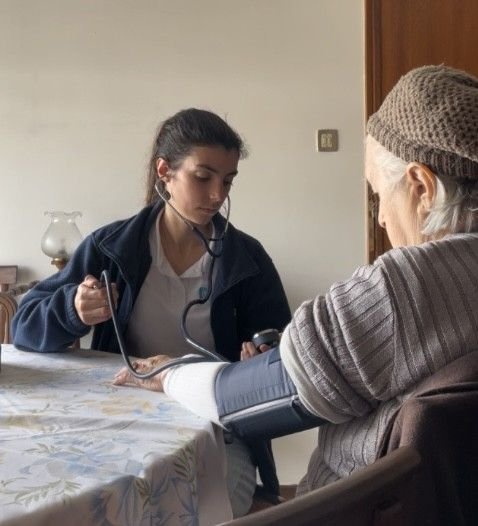 Brave Care nurse measuring blood pressure for an elderly patient at home