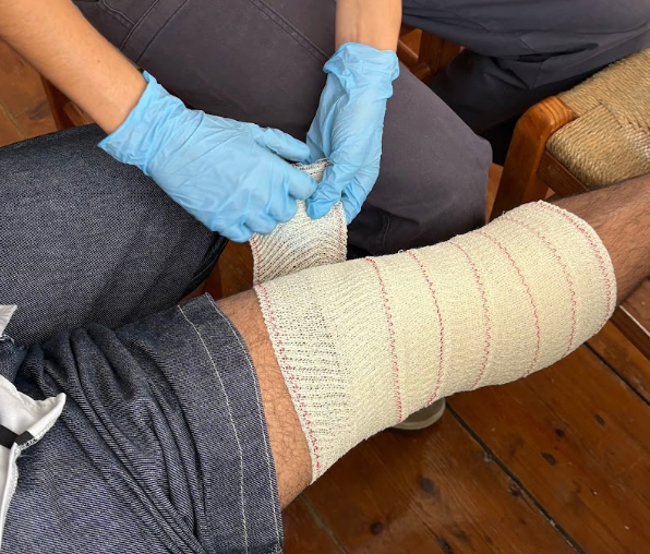 Close-up of a Brave Care nurse applying a bandage to a patient's leg
